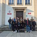 Zdjęcie grupowe studentów – uczestników praktyk terenowych – stojących na schodach przed dużym budynkiem, razem z nimi profesor UPP dr. hab. inż. Adam Zydroń oraz dr. inż. Cyprian Chwiałkowski. Po lewej stronie wejścia widoczna tabliczka z napisem "Dyrekcja Wielkopolskiego Parku Narodowego", a po prawej tabliczka z napisem "Centrum Edukacji Ekologicznej"